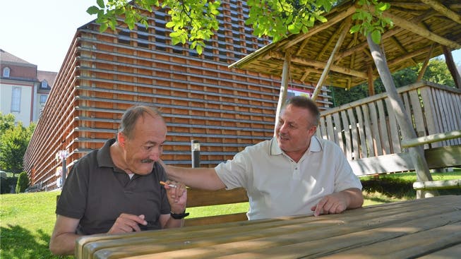 Heimleiter Uwe Tischer zusammen mit Manfred, einem in Muri bekannten Bewohner des Roth-Hauses; im Hintergrund die Beschäftigungsstätte.