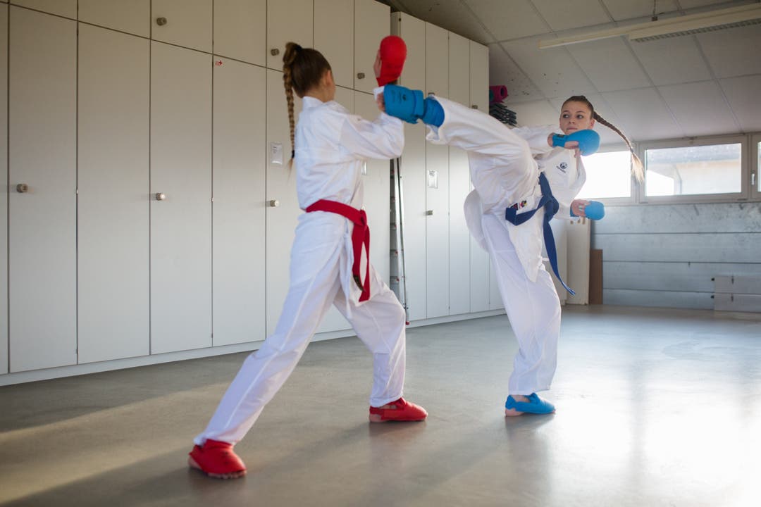 Am Fototermin tragen Gina und Lucia Bortot die Wettkampfkleidung für die Kategorie Kumite (Kampf), lange weisse Sportkimonos.