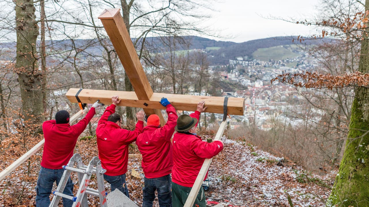 Die Mitarbeiter des Holzbaubetriebs Peterhans, Schibli &amp; Co. stellen das Gipfelkreuz auf