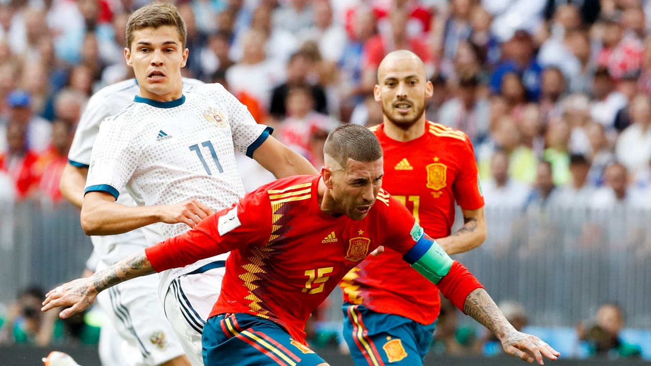 Sergio Ramos (vorne) ist einen Schritt vor Russlands Roman Zobnin am Ball. David Silva im Hintergrund beobachtet den Zweikampf.