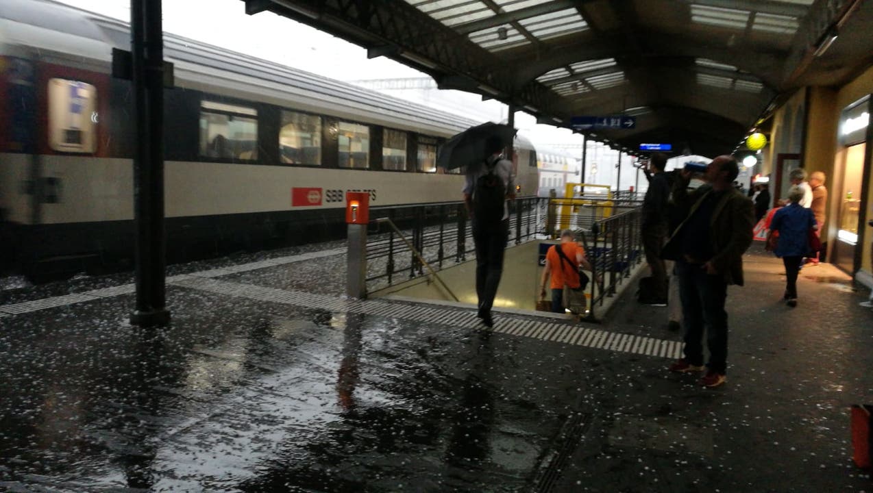 Hagelkörner flogen auf das Perron am Gleis 1. Passanten spannten trotz Dach den Regenschirm auf, um nicht von Hagel-Querschlägern, die am Zug abprallten, getroffen zu werden.