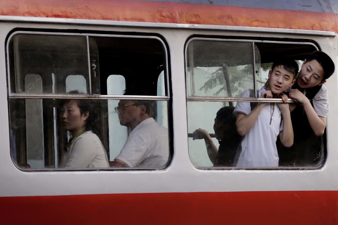 Alltag in Nordkorea - Impressionen Buben schauen aus einem Fenster eines Elektro-Busses, dem häufigsten öffentlichen Verkehrsmittel.