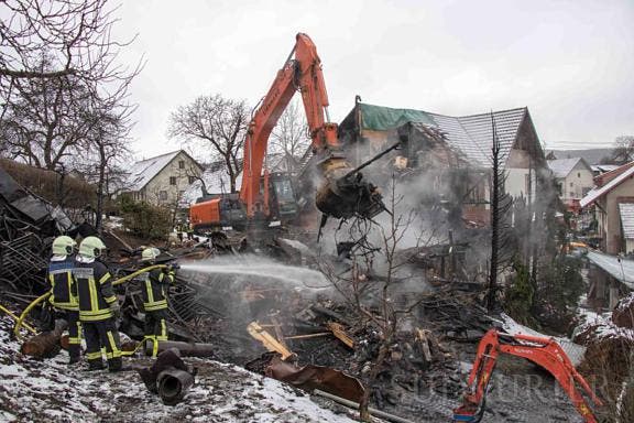 Mithilfe eines Baggers wurden die verbrannten Trümmer des völlig zerstörten Gebäudeteils auf letzte Glutnester abgesucht.
