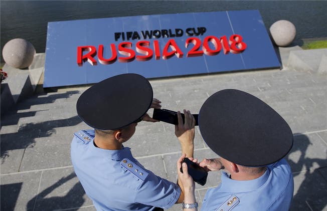 Russische Polizisten vertreiben sich mit ihren Handys die Zeit bei einem Einsatz in St. Petersburg. Nun werden sie von Schweizern unterstützt.REUTERS/Maxim Shemetov