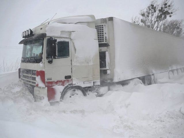 Ein Lastwagen steckt im Schnee fest (Symbolbild)