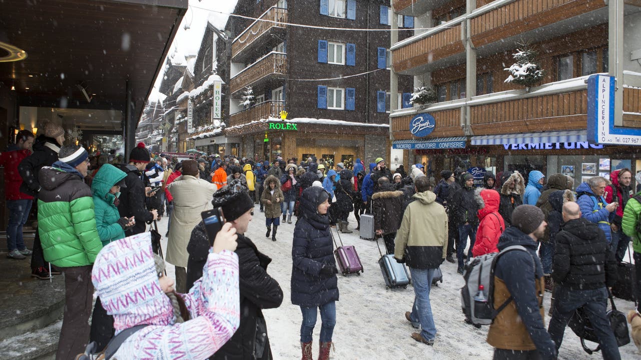 Die Menschen stehen Schlange, um ein Ticket für den Helikopter zu ergattern, der sie aus Zermatt fliegt.