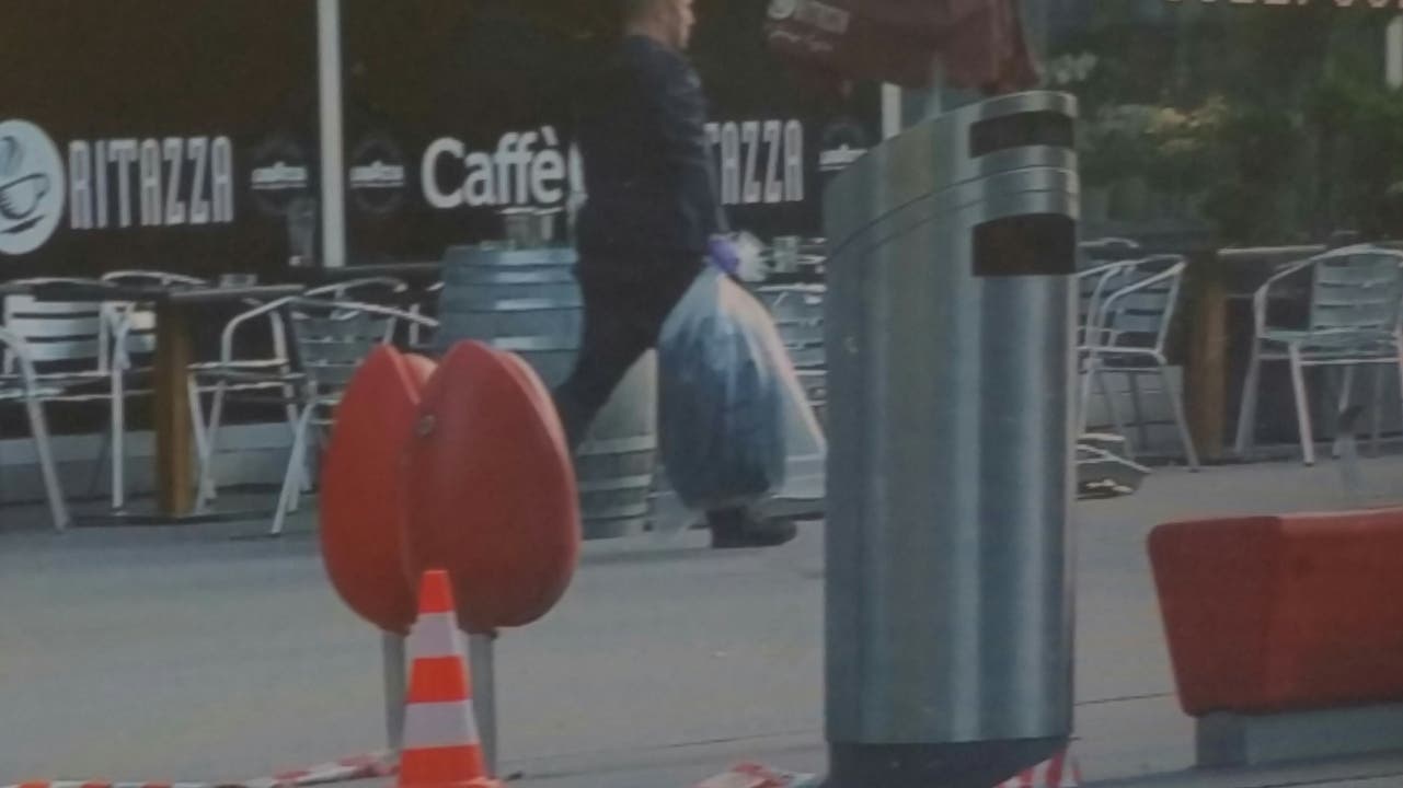 Polizeieinsatz am Bahnhof Aarau: Ein Beamter trägt den verdächtigen Koffer in einem Sack weg.