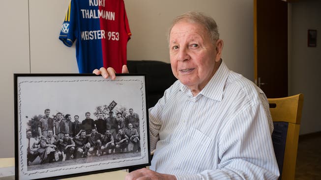 Auch über 60 Jahre nach dem Titel ist der FCB bei Kurt Thalmann noch sehr präsent: in der Hand ein Teamfoto, im Hintergrund ein vom Verein geschenktes Trikot.