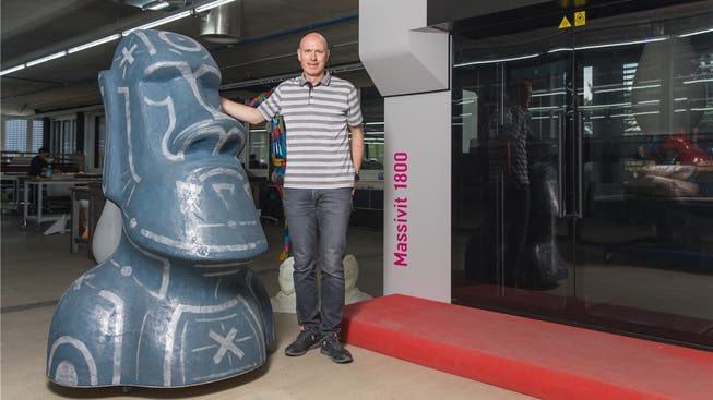 Zwischen dem 3-D-Drucker mit der schwarzen Verglasung (r.) und dessen gedruckter Moai-Statue wirkt Firmeninhaber Claude Lombard fast schon klein.