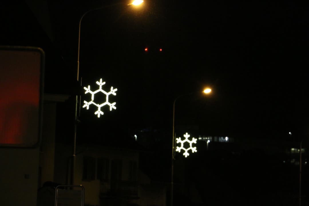 In Sisseln zieren leuchtende Schneeflocken die Kandelaber an der Hauptstrasse.
