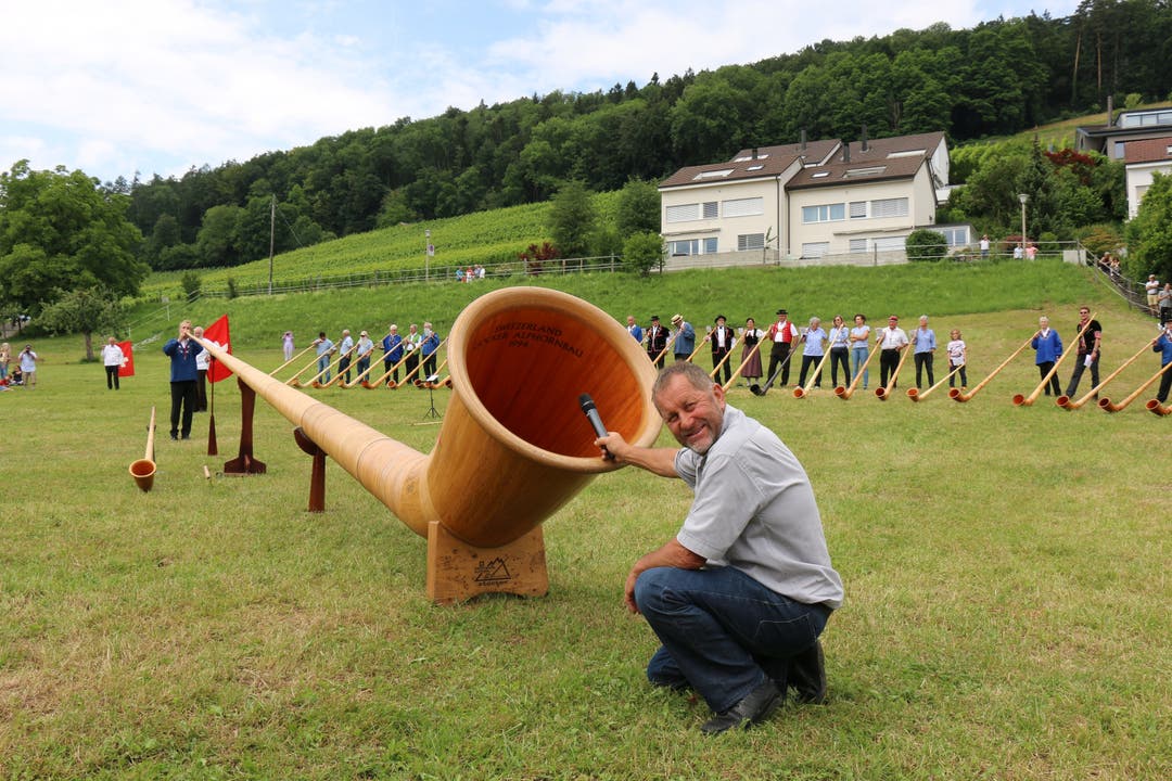 OK-Präsident Hans-Heinrich Haug testet die Akustik des Riesenalphorns von Walti Sigrist.