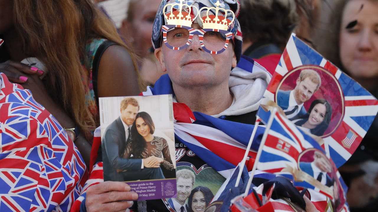 Fans des britischen Königshauses warten am Samstagmorgen vor der St.-Georgs-Kapelle, wo sich Harry und Meghan das Jawort geben.