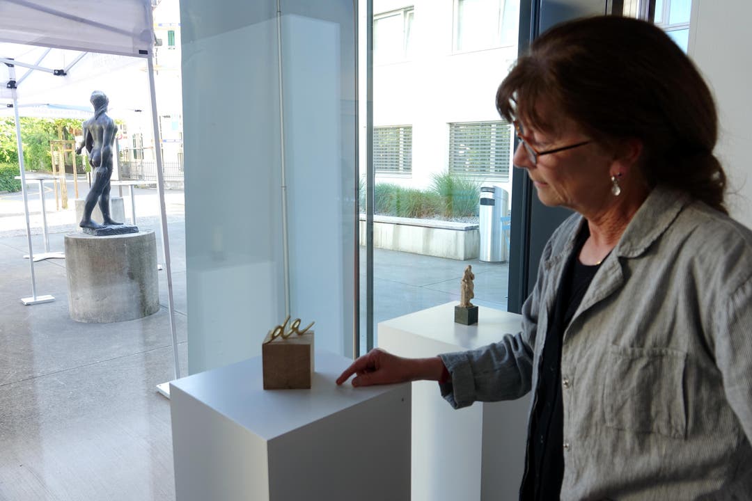 Ursula Rutishauser mit einem ihrer geschnittenen Wortfragmente - mit Blick auf eine Skulptur von Eduard Spörri (Bild ub)