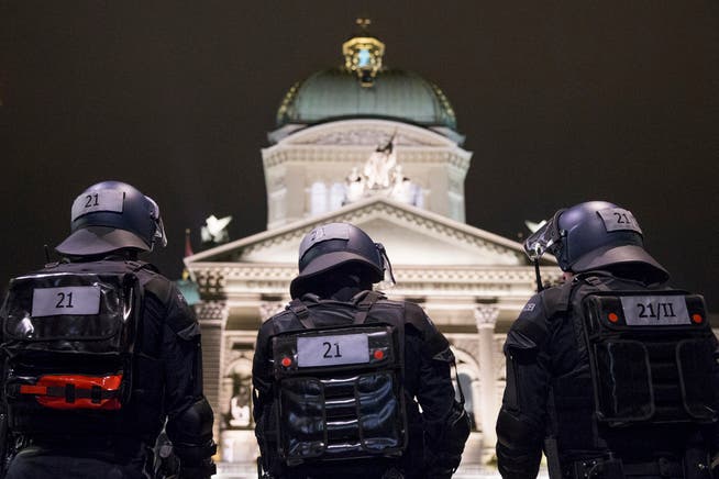 Polizisten beobachten das Bundeshaus und den Bundesplatz.