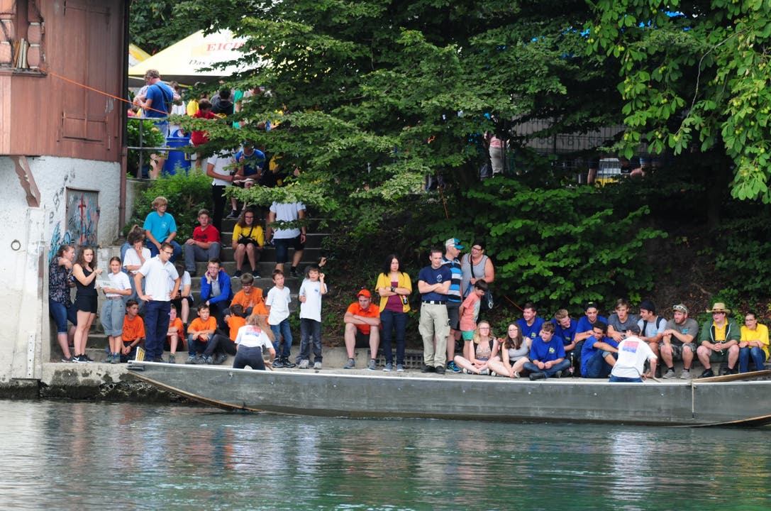 Die Zuschauer verfolgen das Geschehen vom Ufer aus.