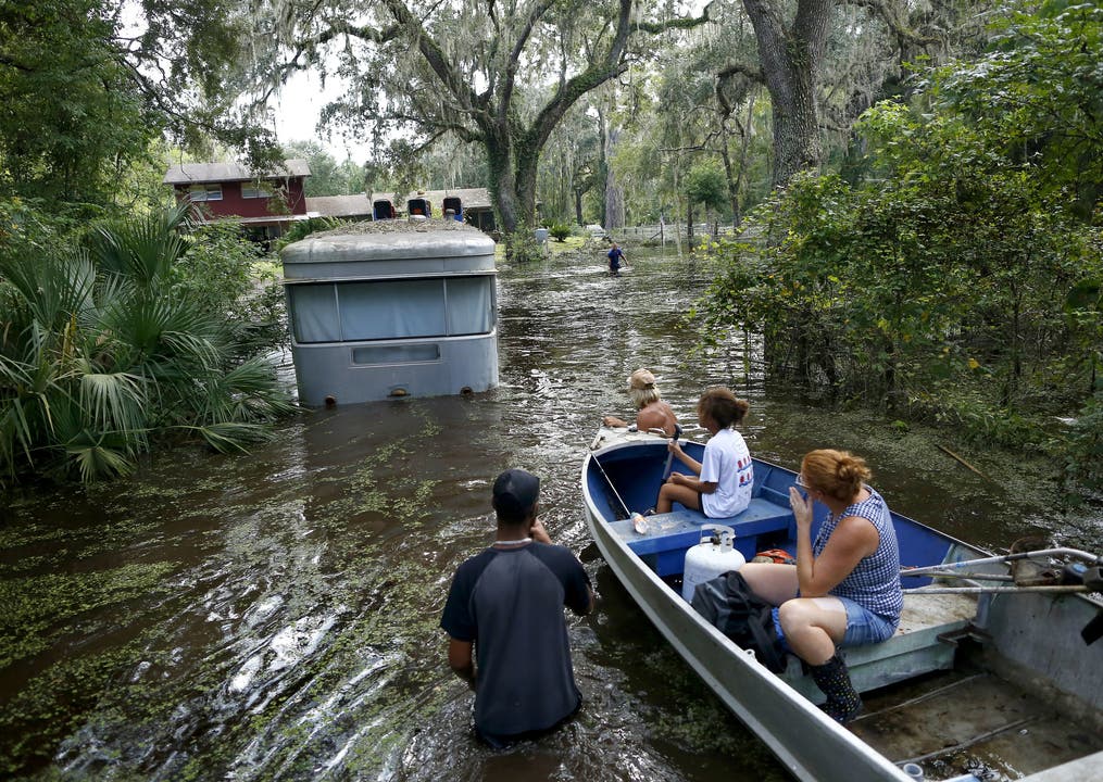 Mitglieder einer Familie fahren auf einem Boot, vor sich ein Anhänger im Wasser. (Gainesville, Florida)