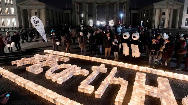Hier im Bild: Kerzen brennen vor dem im Dunkeln stehenden Brandenburger Tor in Berlin: Zur Earth Hour wurden in über 7000 Städten die Lichter an Sehenswürdigkeiten ausgeschaltet. Im Zeichen des Klimaschutzes.