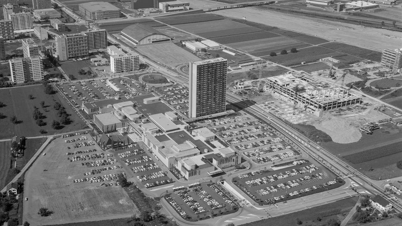 1971 steht links das umjubelte «Shoppi» mit Hochhaus und übervollem Parkplatz, rechts wird am «Tivoli» gebaut und im Hintergrund an der Autobahn N1.