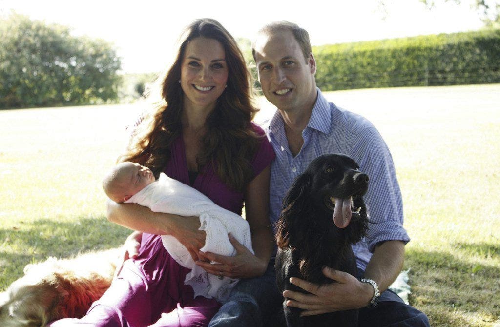 Kates Vater Michael Middleton schoss dieses Foto von Kate und William mit Baby George. Mit dabei die beiden Hunden Tilly und Lupo. (August 2013)