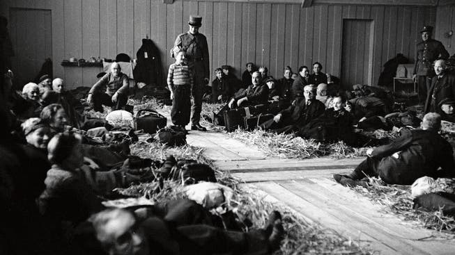 Robert Narev (Bildmitte) mit einem Soldaten nach der Ankunft im Hadwig-Schulhaus im Februar 1945. Die Turnhalle wurde damals als Strohlager für jüdische Flüchtlinge hergerichtet.