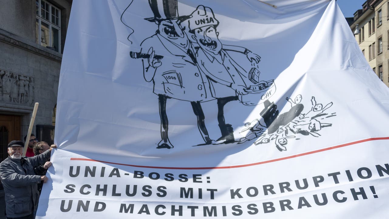 1. Mai in Basel: EIn Mann haelt ein Transparent mit der Aufschrift "Unia-Bosse: Schluss mit Korruption und Machtmissbrauch!"