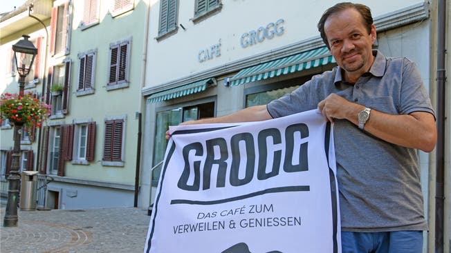 Klaus Kaiser präsentiert sein Logo vor dem Café.