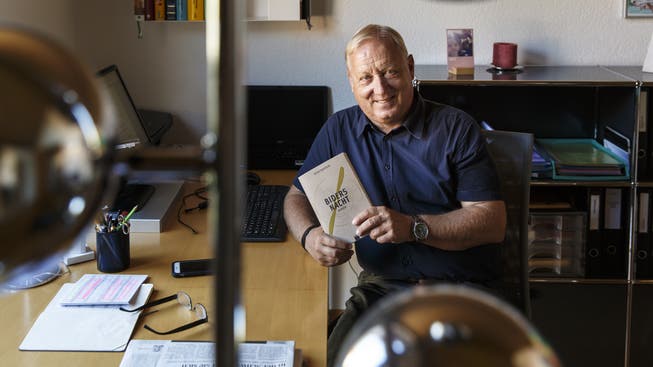 Autor Peter Brotschi in seinem Büro mit seinem Erstlingsroman «Biders Nacht».