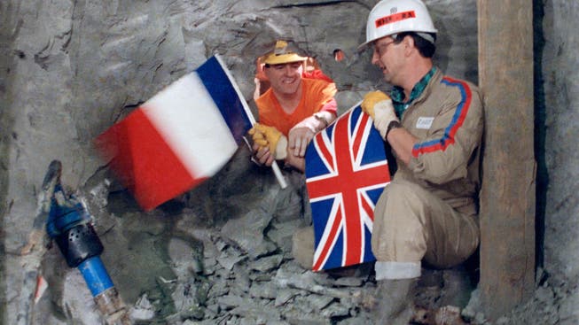Am 1. Dezember 1990 reichen sich französische und britische Arbeiter durchs Durchbruchloch die Hand. Vier Jahre später wird der Eurotunnel eingeweiht.