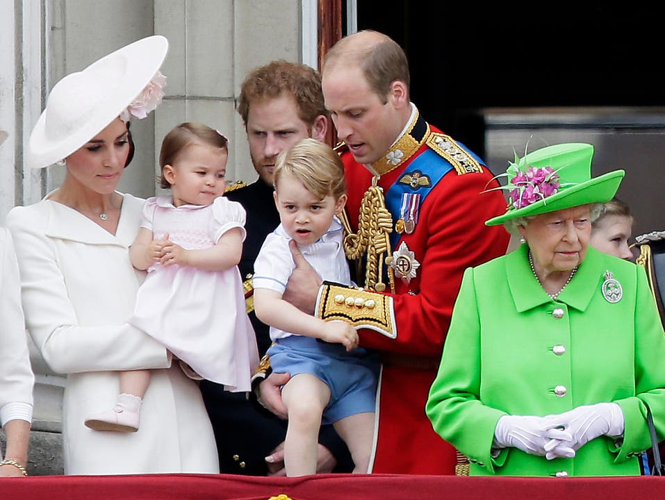 Alle Augen auf die Jüngsten der königlichen britischen Familie: Prinzessin Charlotte (links, auf dem Arm von Herzogin Kate) und Prinz George (auf dem Arm von Prinz William) auf dem Balkon des Buckingham Palace in London. Gefeiert wird der 90. Geburtstag von Queen Elizabeth II. (rechts im Bild).