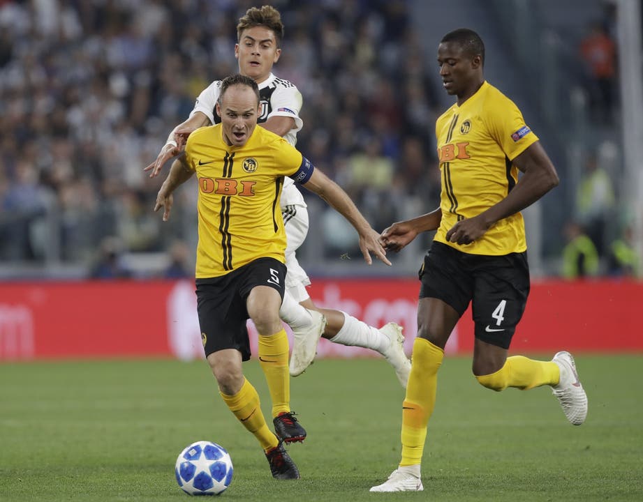 Italy Soccer Champions League Juventus forward Paulo Dybala and Young Boys' Steve von Bergen, left, vie for the ball as Young Boys' Mohamed Ali Camara, right, looks at them, during the Champions League, group H soccer match between Juventus and Young Boys, at the Allianz stadium in Turin, Italy, Tuesday, Oct. 2, 2018. (AP Photo/Luca Bruno)