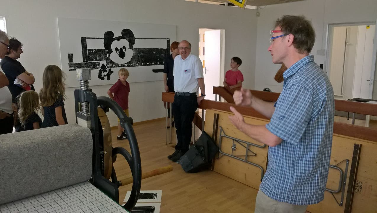 Thomas Ruch erläutert verschiedene Druckarten hinten Triennale-Präsident Philipp Glocker