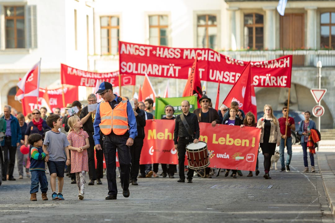 Auch in Aarau lief die 1.Mai-Demo ohne Zwischenfälle ab. Kinder bewundern den Polizisten, der vor dem Umzug mitläuft.