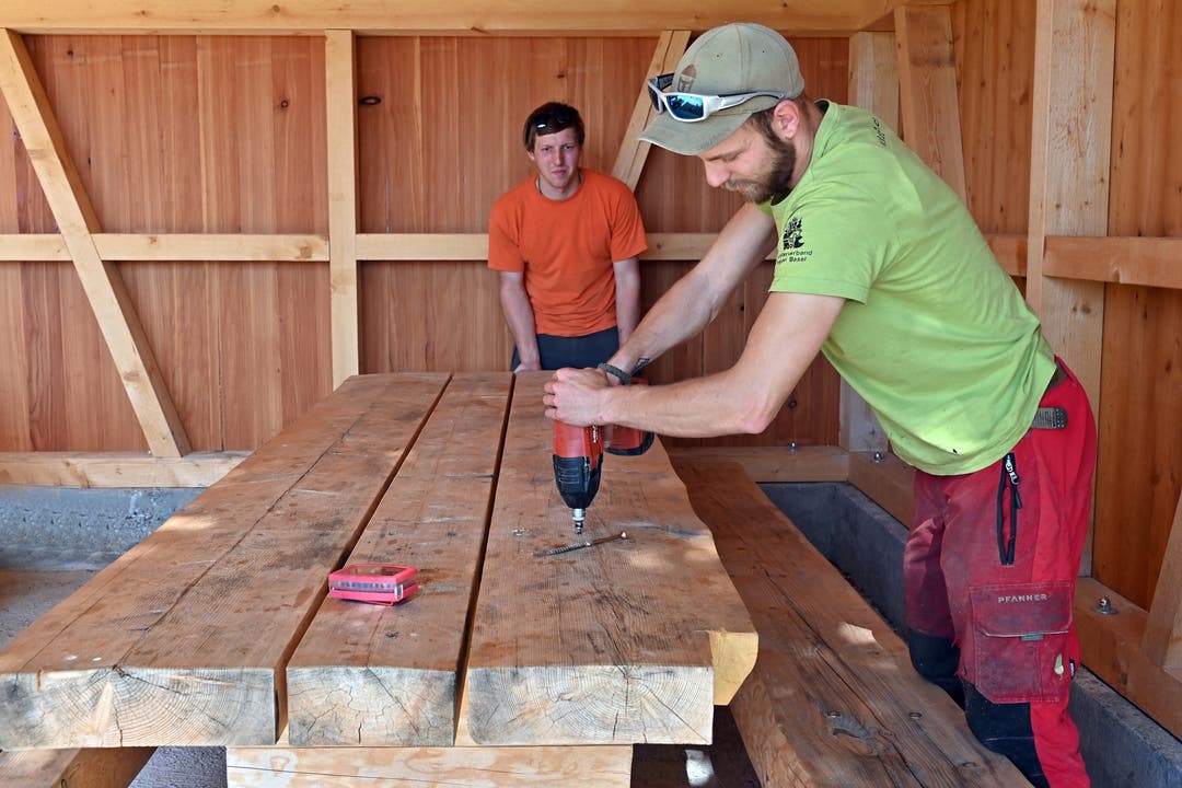 Mitarbeiter des Forstbetriebes Mümliswil montieren den kaputten Teil der Tischplatte ab