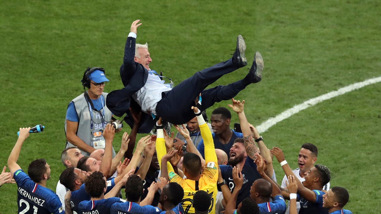 Frankreichs Trainer Didier Deschamps wird von den Spielern in die Luft geworfen. French players throw France head coach Didier Deschamps into the air celebrating at the end of the final match between France and Croatia at the 2018 soccer World Cup in the Luzhniki Stadium in Moscow, Russia, Sunday, July 15, 2018. (AP Photo/Thanassis Stavrakis)