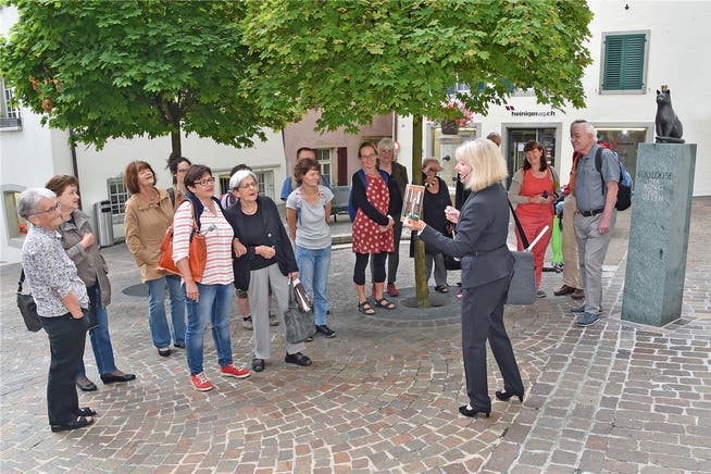Stadtführerin Emma Anna Studer beim Rundgang mit ihrem Publikum, kurz bevor der Regen einsetzte. Die Toulouse-Bronzeskulptur stammt vom Balsthaler Bildhauer Norbert Eggenschwiler.