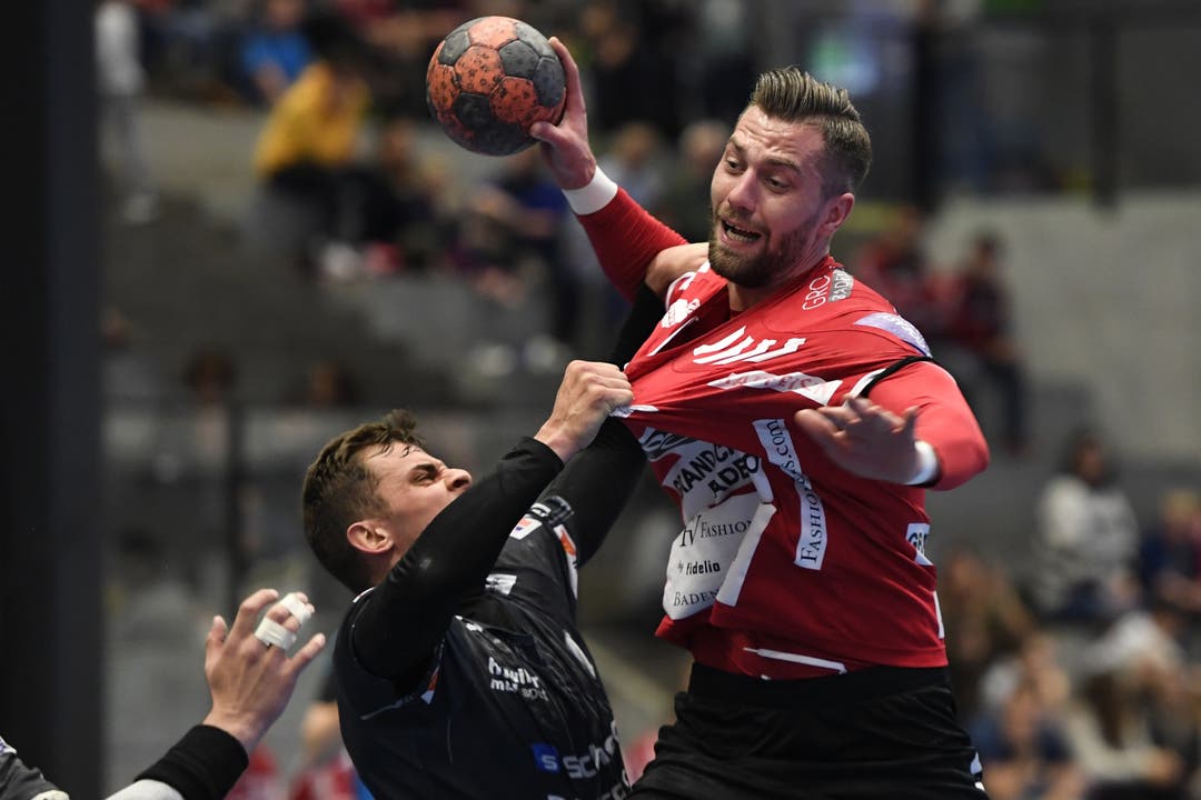Handball, NLB: TV Endingen - STV Baden Pascal Bühler (links, Baden) reisst Joel Huesmann (rechts, TVE) am Trikot.