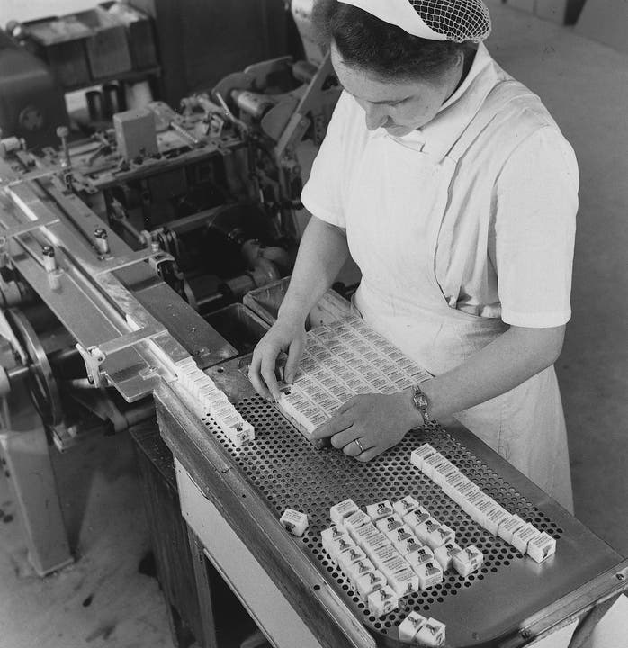Eine Angestellte zählt und sortiert die verpackten Zuckerwürfel. (um 1950)