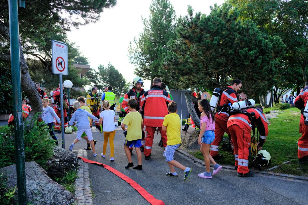 Die Kinder bahnen sich ihren Weg an den Feuerwehrleuten vorbei...