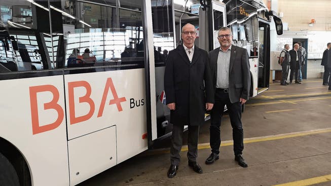 Präsident Peter Forster und Geschäftsführer Peter Baertschiger (r.) vor einem der neuen Hybridbusse.