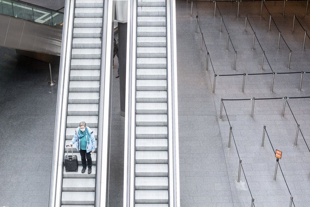 Eine einzelne Frau auf Reisen: Die Rolltreppen vor der Zollkontrolle am Flughafen Zürich.