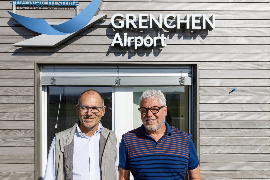 Fughafendirektor Ernest Oggier (links) und Architekt Ivo Erard mit dem neuen Flughafen-Logo im Hintergrund