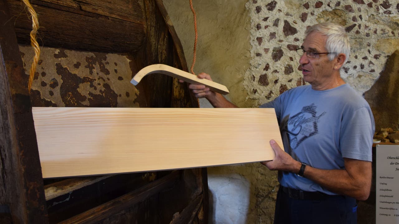  Museumskurator Albert Wey zeigt, wie das Holz für die Wassertasche gebogen und später ins Wasserrad eingesetzt werden muss.