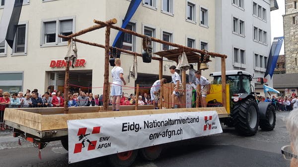Der Eidgenössische Nationalturnverband mit Traktorwagen und Kuhglocken