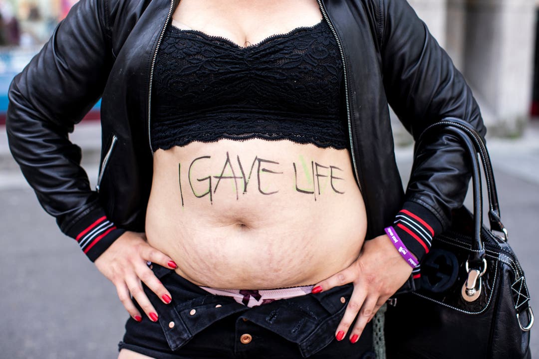 Eine Frau zeigt ihren Bauch mit der Aufschrift "I GAVE LIFE" am nationalen Frauenstreik am Freitag, 14. Juni 2019, in Luzern.