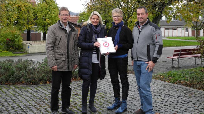Hannes Erb und Melanie Jenni (v.l.) übergeben die Petition mit 571 Unterschriften für die Einführung von Tempo 30 an Gemeindeammann Regine Leutwyler und Vizeammann Georg Schmid.