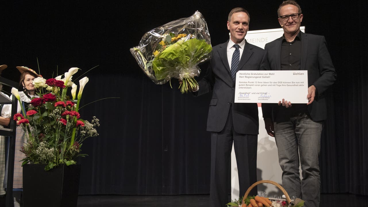 Jean-Pierre Gallati erhält vom Wohler SP-Gemeindeammann Arsène Perroud Blumen und einen Yogagutschein.