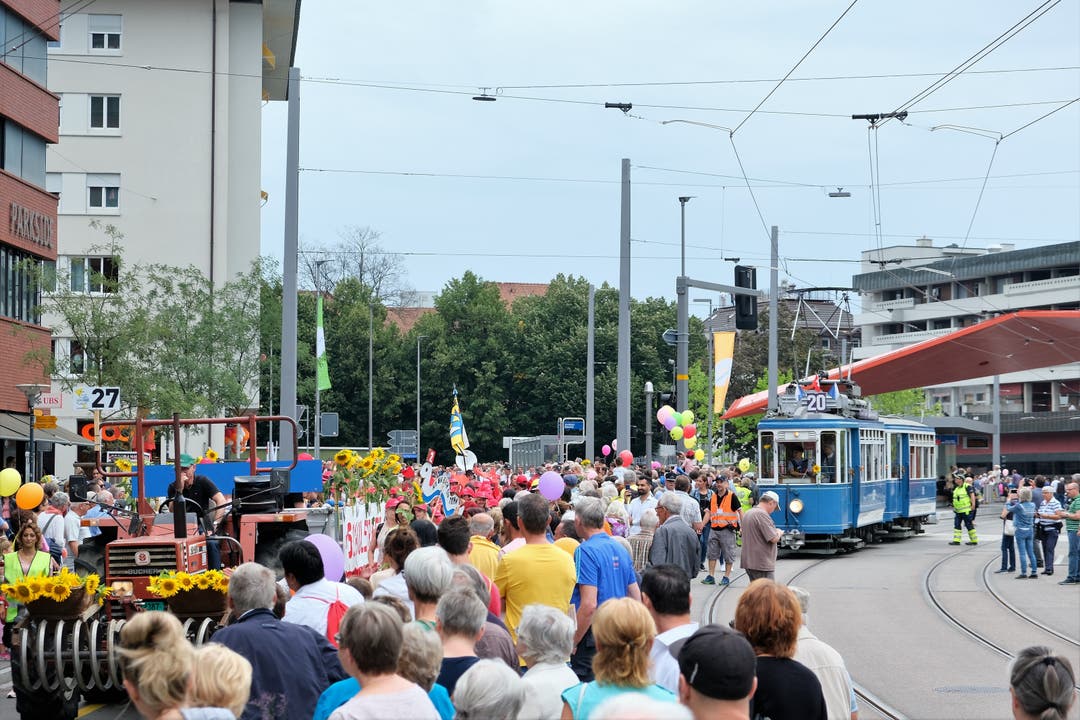 Links nähern sich die Schülerinnen und Schüler aus den Schlieremer Schulhäusern Grabenstrasse und Schulstrasse, rechts das historische Tram.