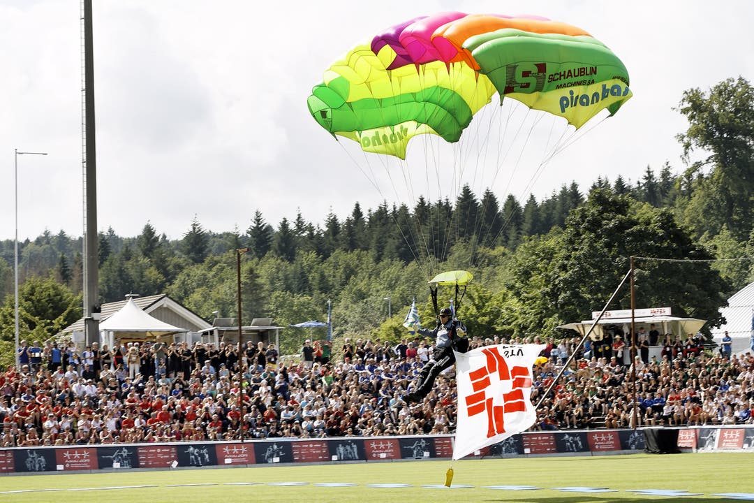 ETF 2019 Schlussfeier des Eidgenössischen Turnfestes in Aarau: Ein Gleitschirmflieger mit der STV-Fahne landet im Stadion.
