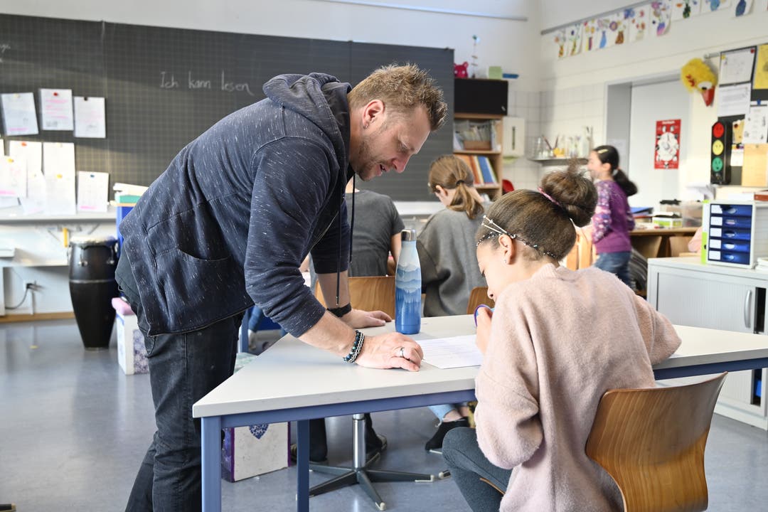 Cédric Bellini hilft einer Schülerin beim Entziffern der Blindensprache.