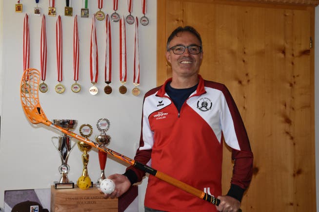 Jürg Leibundgut vor einer Auswahl an Medaillen und Pokalen, die er mit den Waldstätter Schülerteams gewonnen hat.